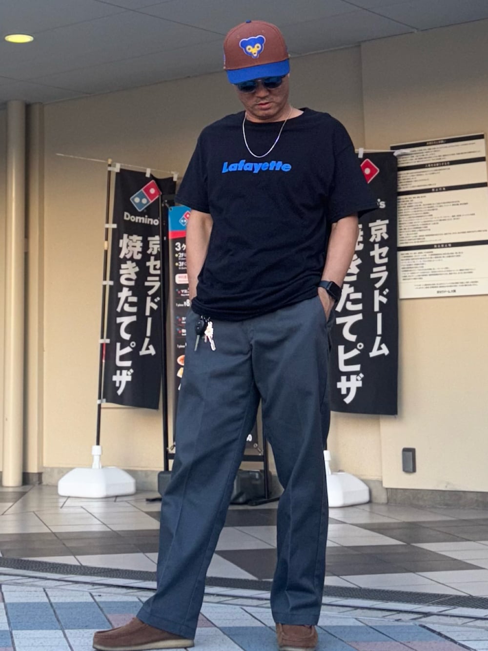 グレー系のチノパンツ、ブラック系のTシャツ/カットソー、ブラウン系のモカシン/デッキシューズを着用したメンズの秋コーディネートの2枚目の写真