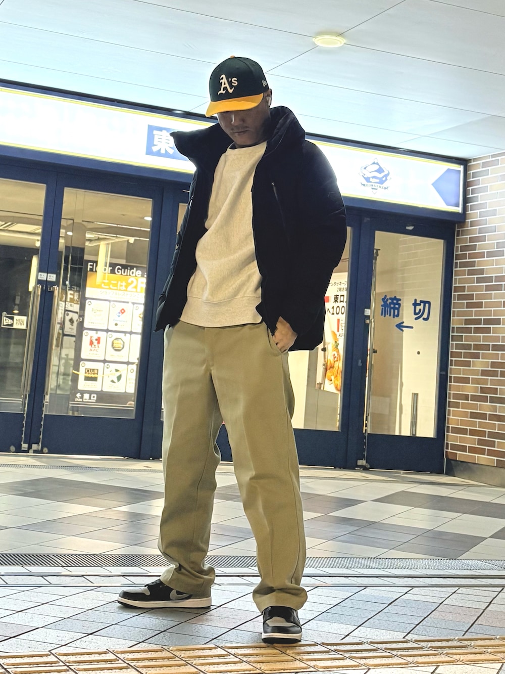 ブラック系のダウンジャケット/コート、ベージュ系のチノパンツ、グレー系のスニーカーを着用したメンズの冬コーディネートの2枚目の写真