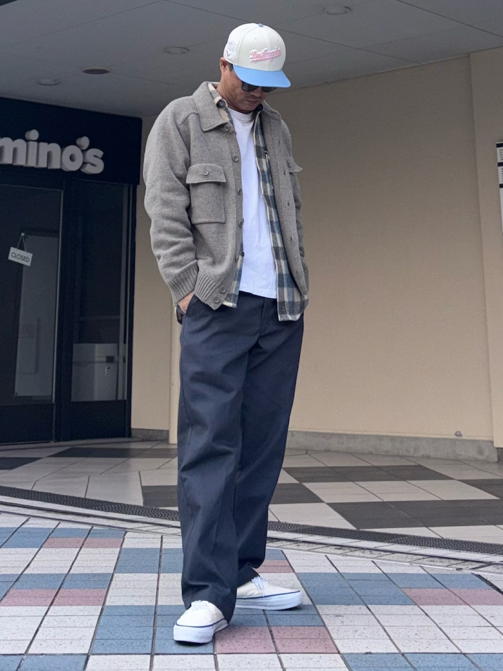 グレー系のニット/セーター、グレー系のチノパンツ、ホワイト系のスニーカーを着用したメンズの冬コーディネートの3枚目の写真