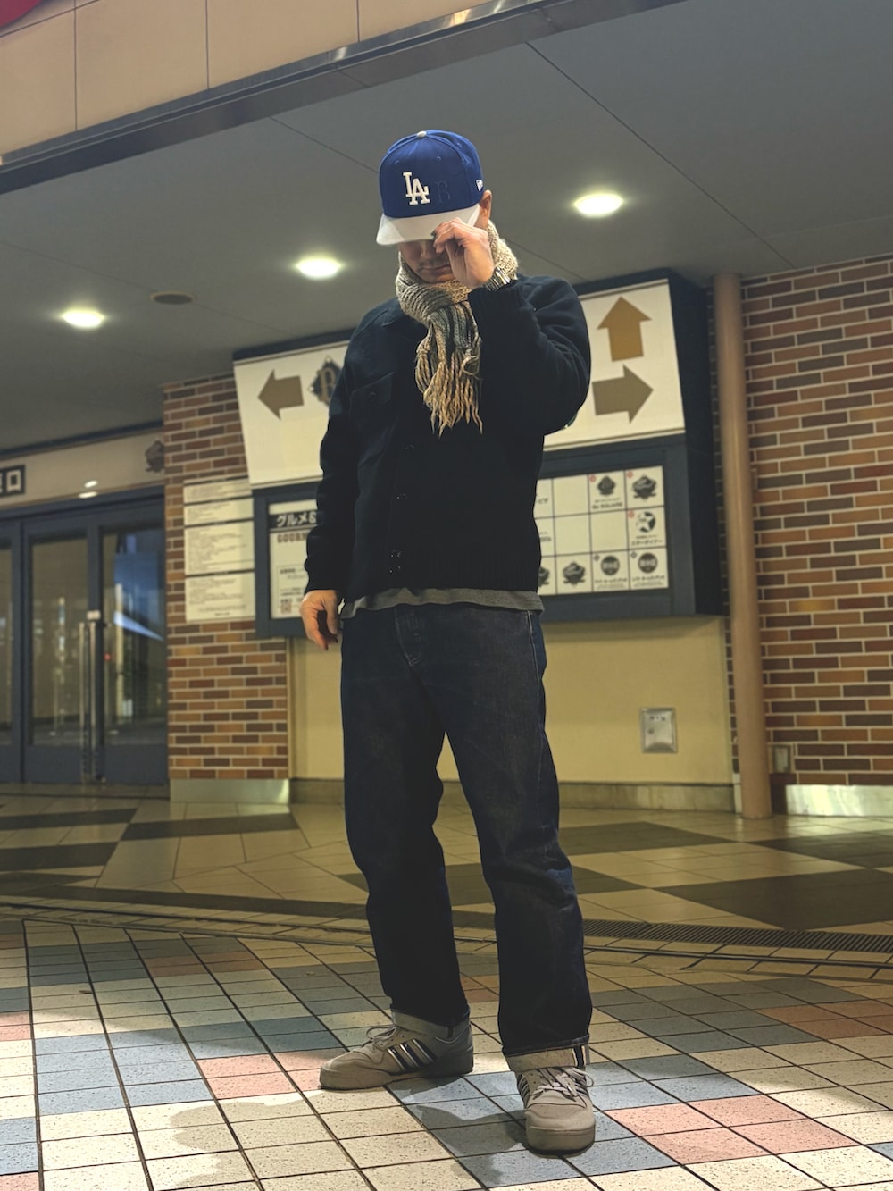 ブラック系のニット/セーター、ブルー系のデニムパンツ、グレー系のスニーカーを着用したメンズの冬コーディネートの2枚目の写真