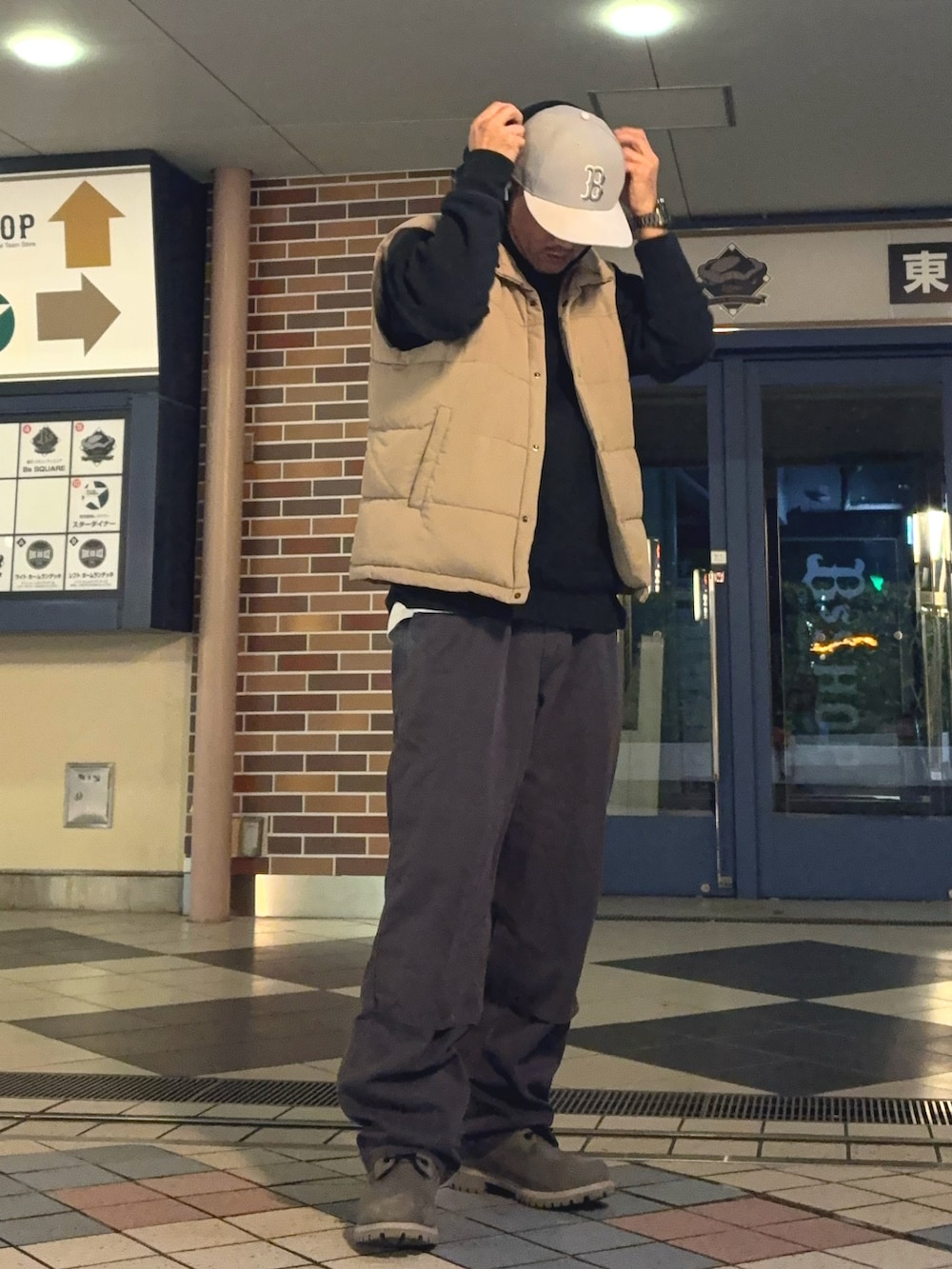 ベージュ系のダウンベスト、パープル系のその他パンツ、グレー系のブーツを着用したメンズの冬コーディネートの2枚目の写真