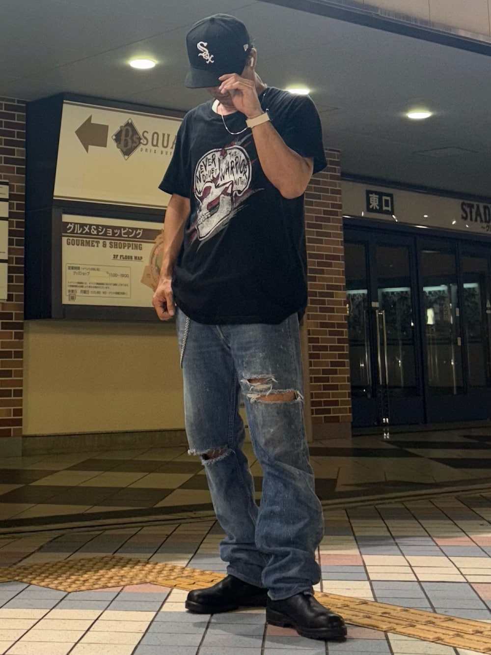 ブラック系のブーツ、ブラック系のTシャツ/カットソー、ブルー系のデニムパンツを着用したメンズの秋コーディネートの2枚目の写真