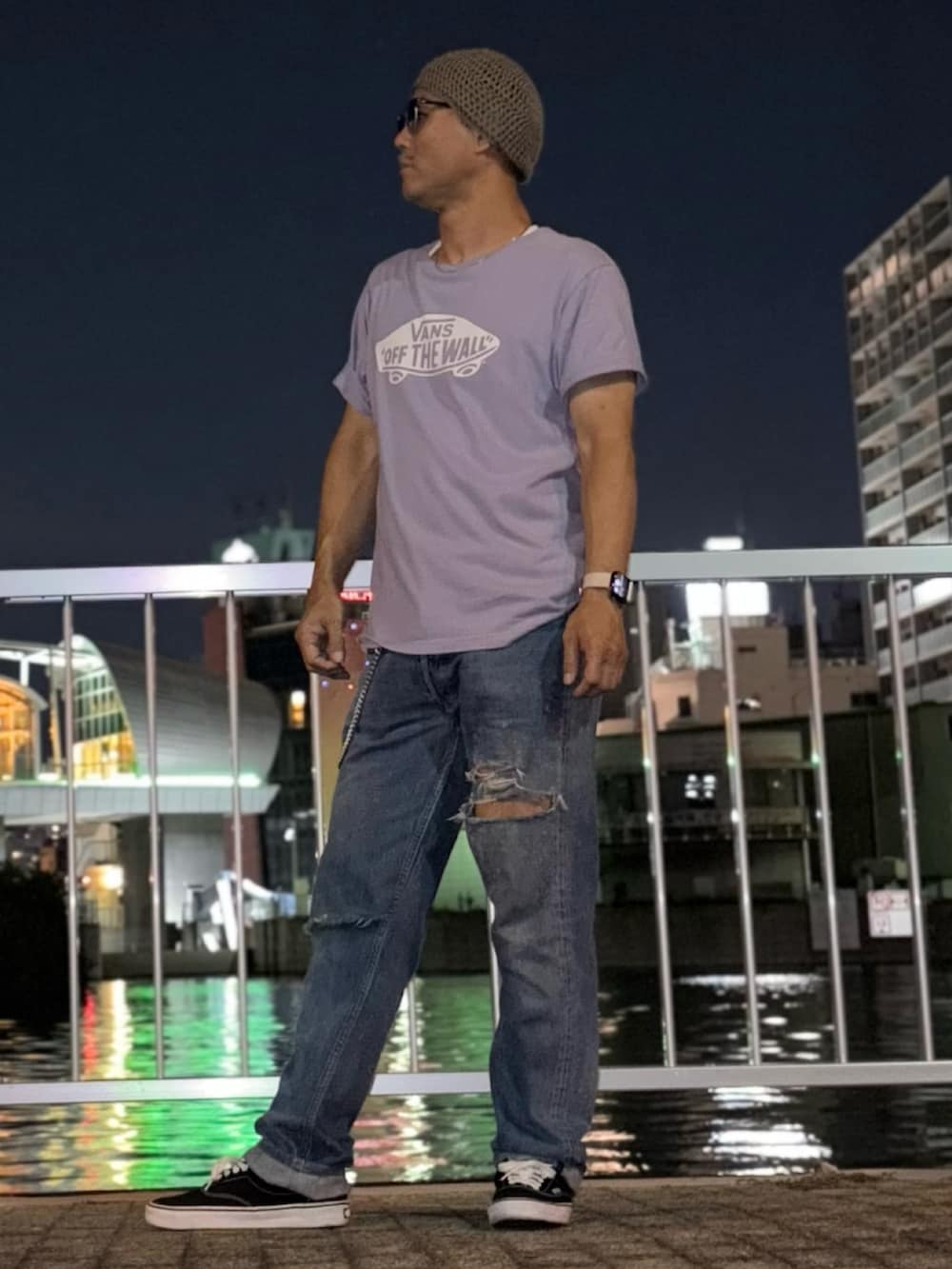 ブラック系のスニーカー、パープル系のTシャツ/カットソー、ブルー系のデニムパンツを着用したメンズの夏コーディネートの2枚目の写真