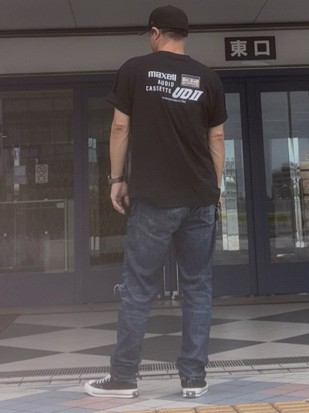 ブラック系のTシャツ/カットソー、ブルー系のデニムパンツ、ブラック系のスニーカーを着用したメンズの夏コーディネートの2枚目の写真