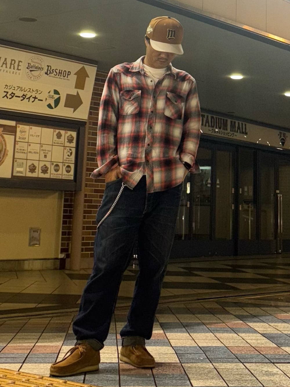 レッド系のシャツ/ブラウス、ブルー系のデニムパンツ、ブラウン系のモカシン/デッキシューズを着用したメンズの秋コーディネートの2枚目の写真