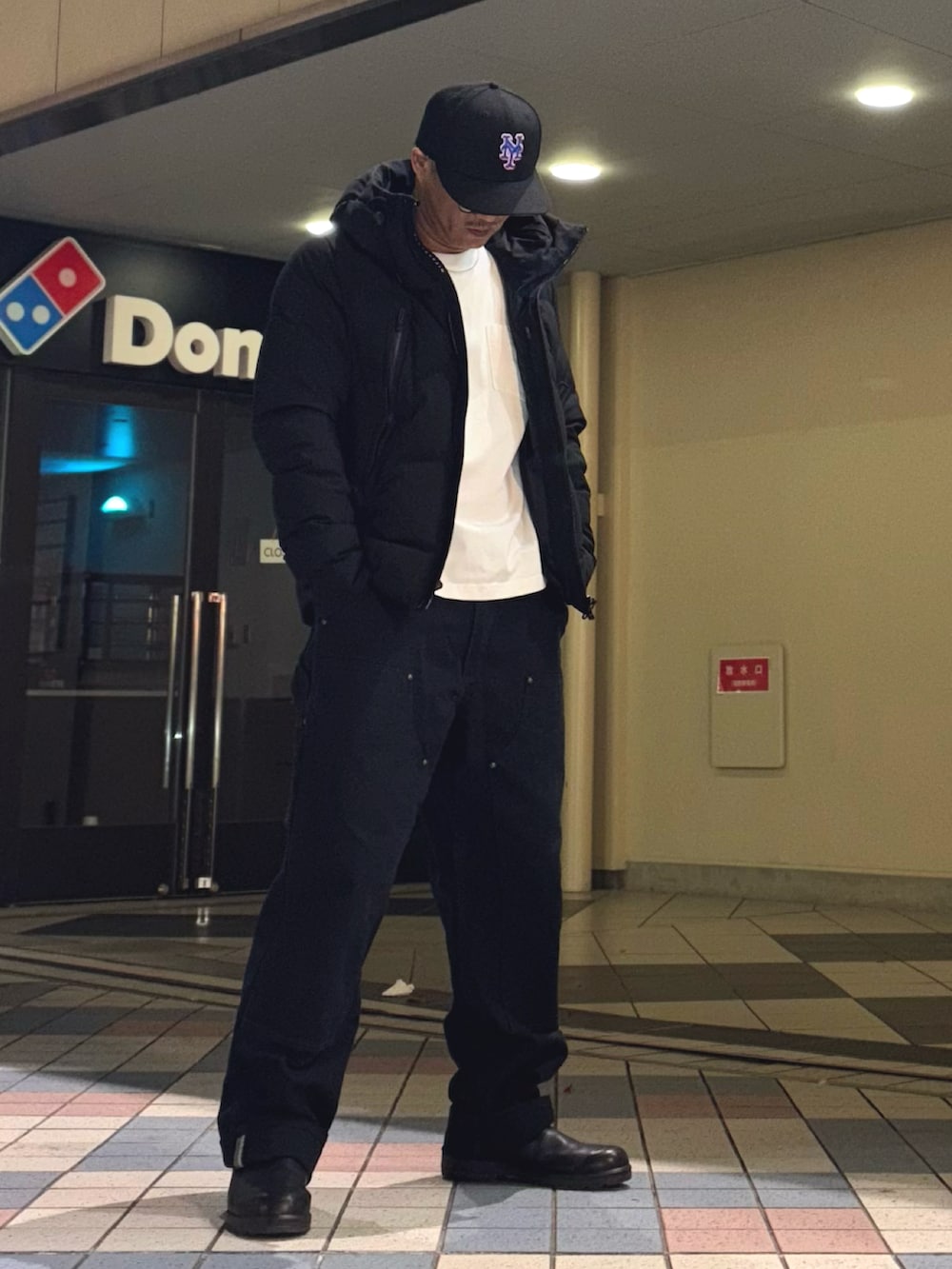 ブラック系のダウンジャケット/コート、ブラック系のその他パンツ、ブラック系のブーツを着用したメンズの冬コーディネートの2枚目の写真