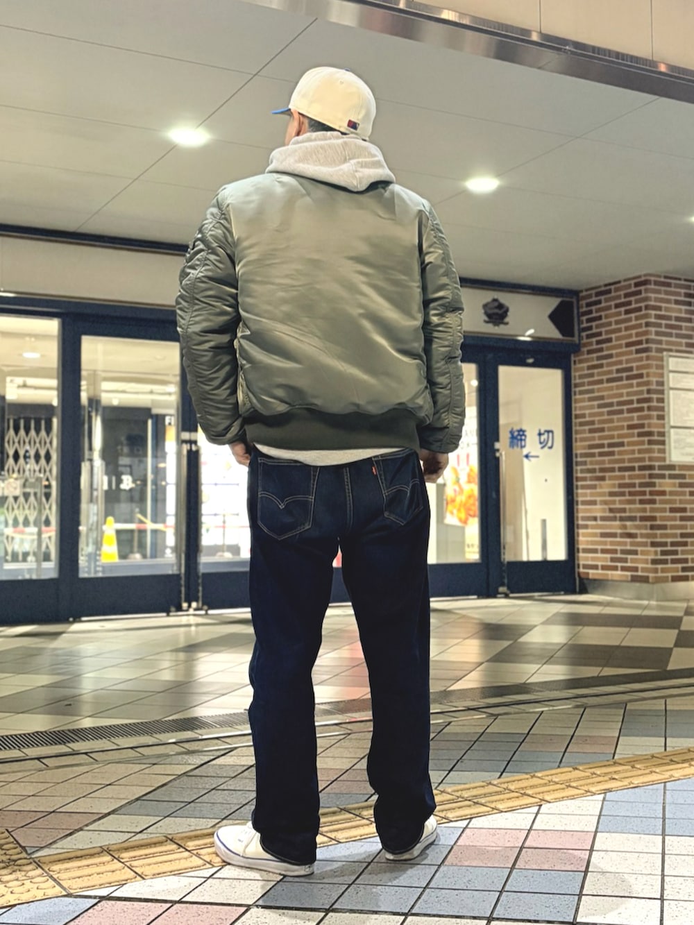 その他のMA-1、グレー系のパーカー、ブルー系のデニムパンツを着用したメンズの冬コーディネートの2枚目の写真