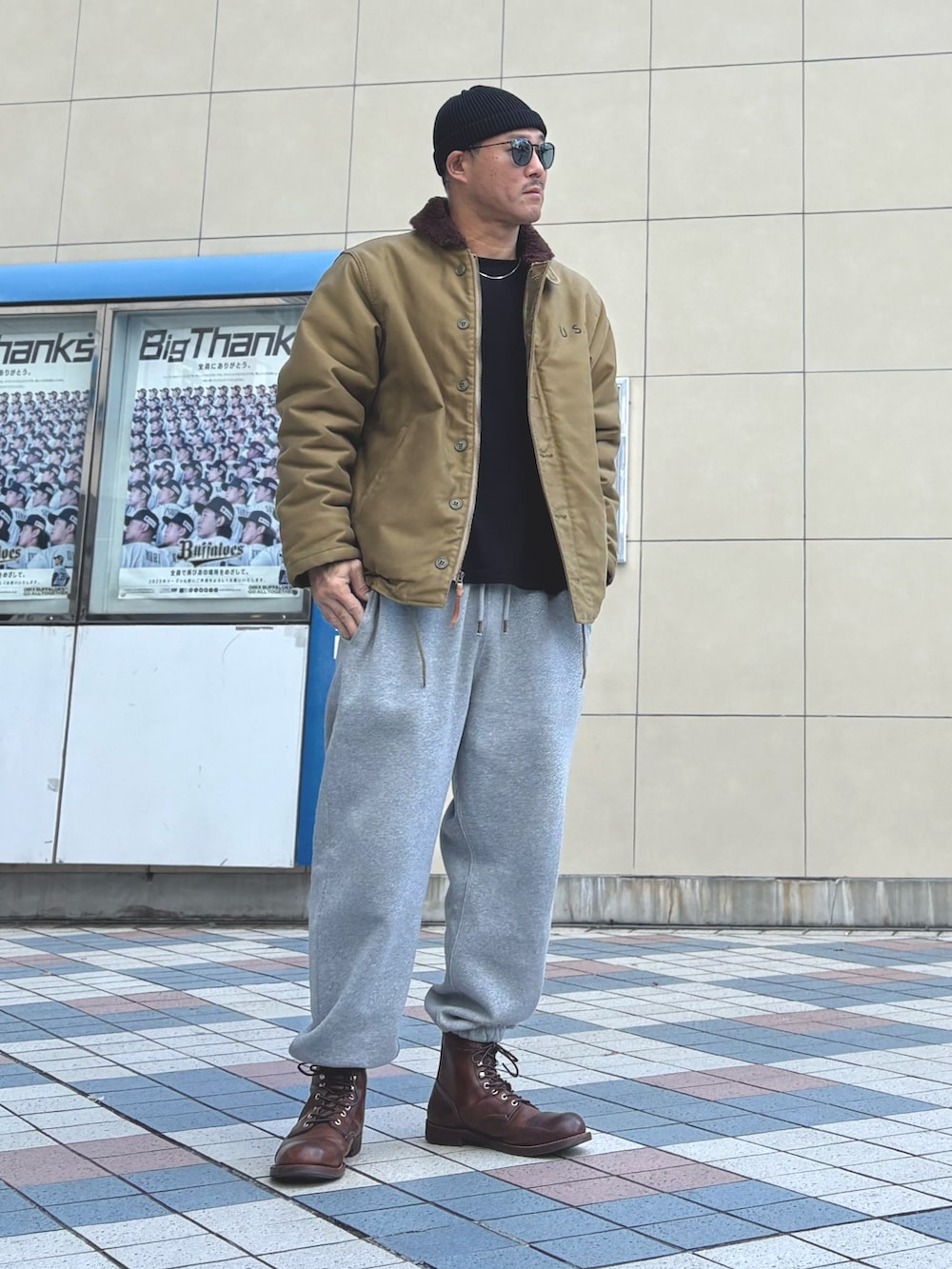 ブラウン系のブーツ、その他のミリタリージャケット、グレー系のスウェットパンツを着用したメンズの冬コーディネートの3枚目の写真