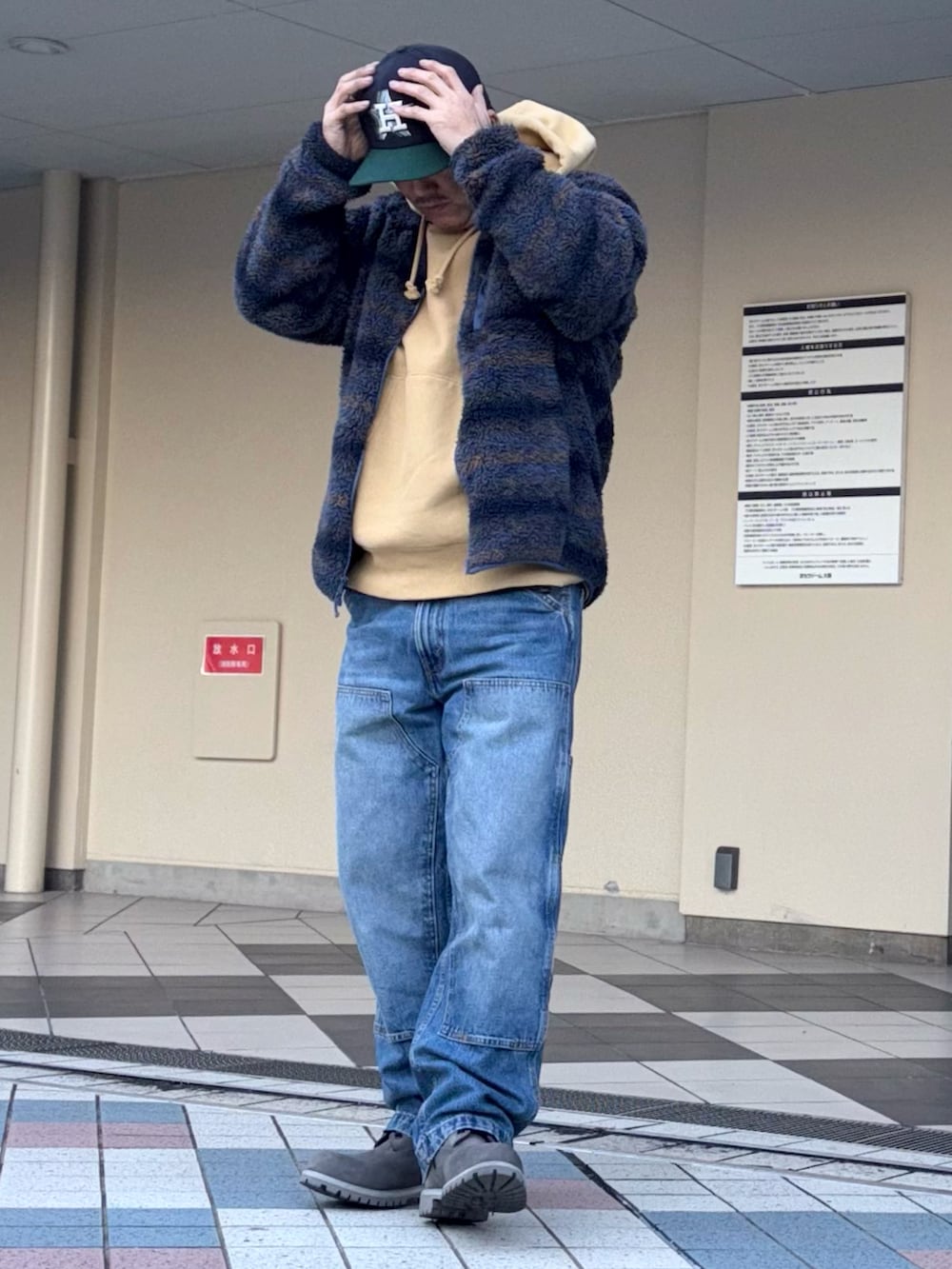 ブルー系のその他アウター、イエロー系のパーカー、ブルー系のデニムパンツを着用したメンズの冬コーディネートの2枚目の写真