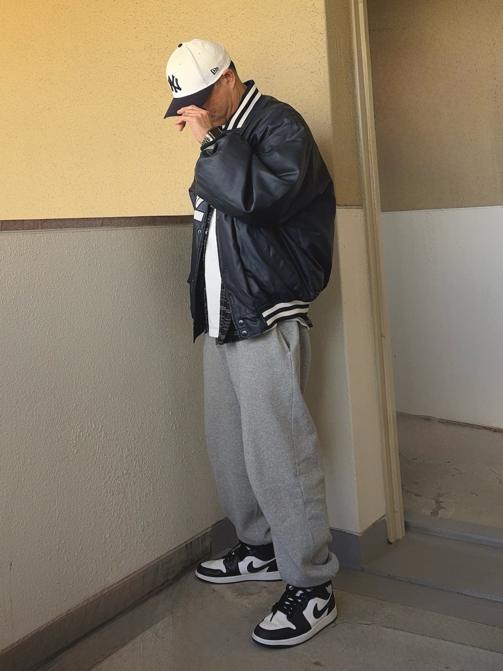 ブルー系のスタジャン、ホワイト系のスニーカー、グレー系のスウェットパンツを着用したメンズの冬コーディネートの2枚目の写真