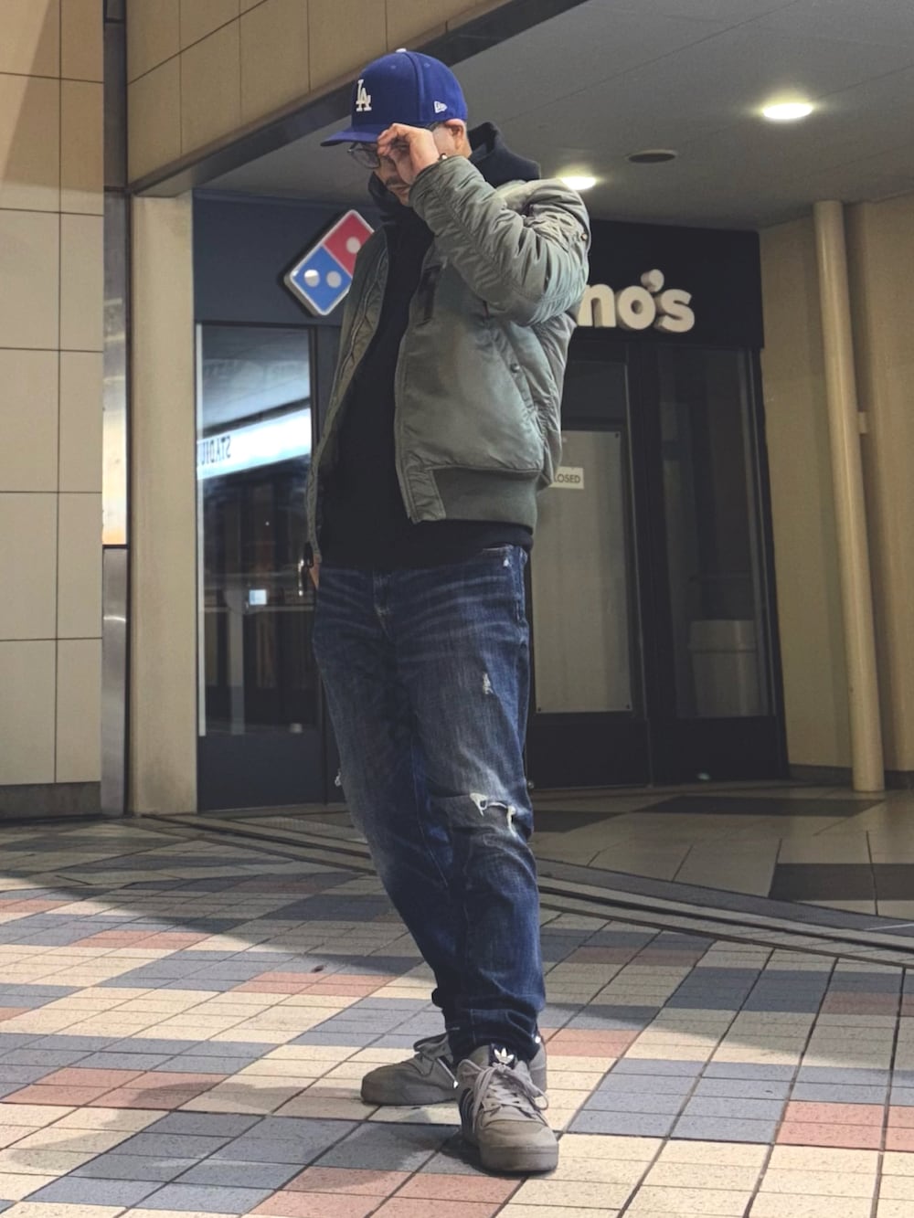 その他のMA-1、ブラック系のパーカー、ブルー系のデニムパンツを着用したメンズの冬コーディネートの2枚目の写真