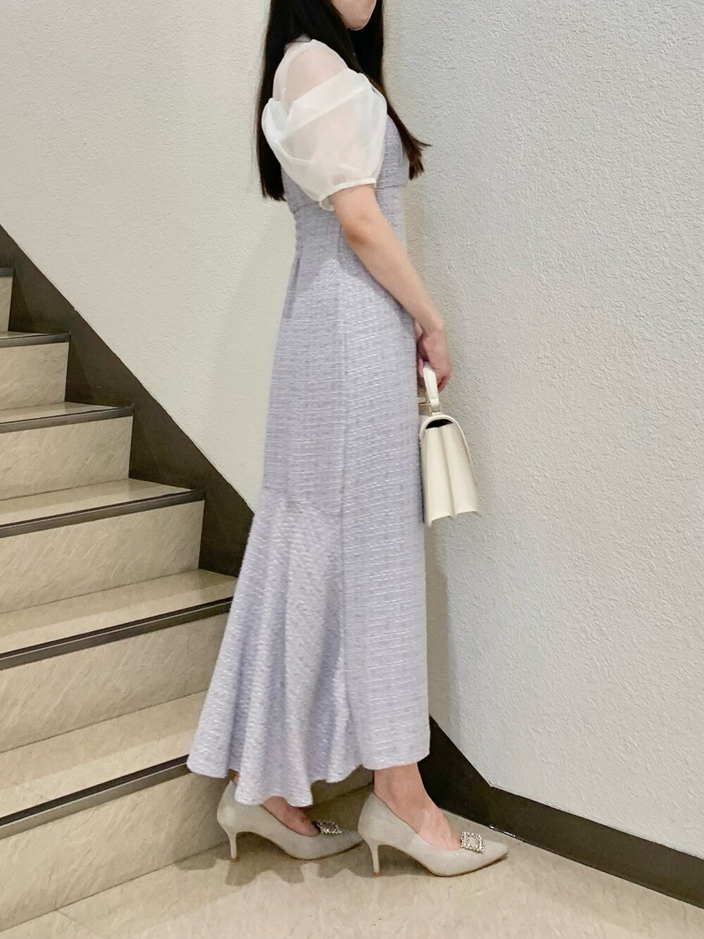 ホワイト系のハンドバッグ、パープル系のワンピース、ホワイト系のパンプスを着用したレディースの夏コーディネートの3枚目の写真