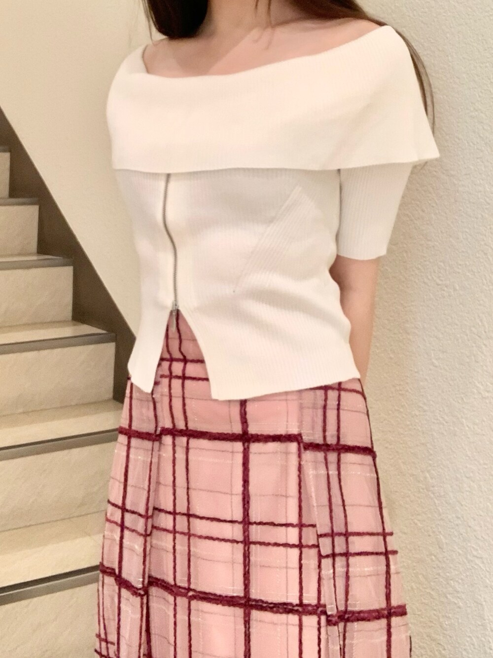ピンク系のスカート、ホワイト系のニット/セーター、ブラウン系のブーツを着用したレディースの夏コーディネートの4枚目の写真