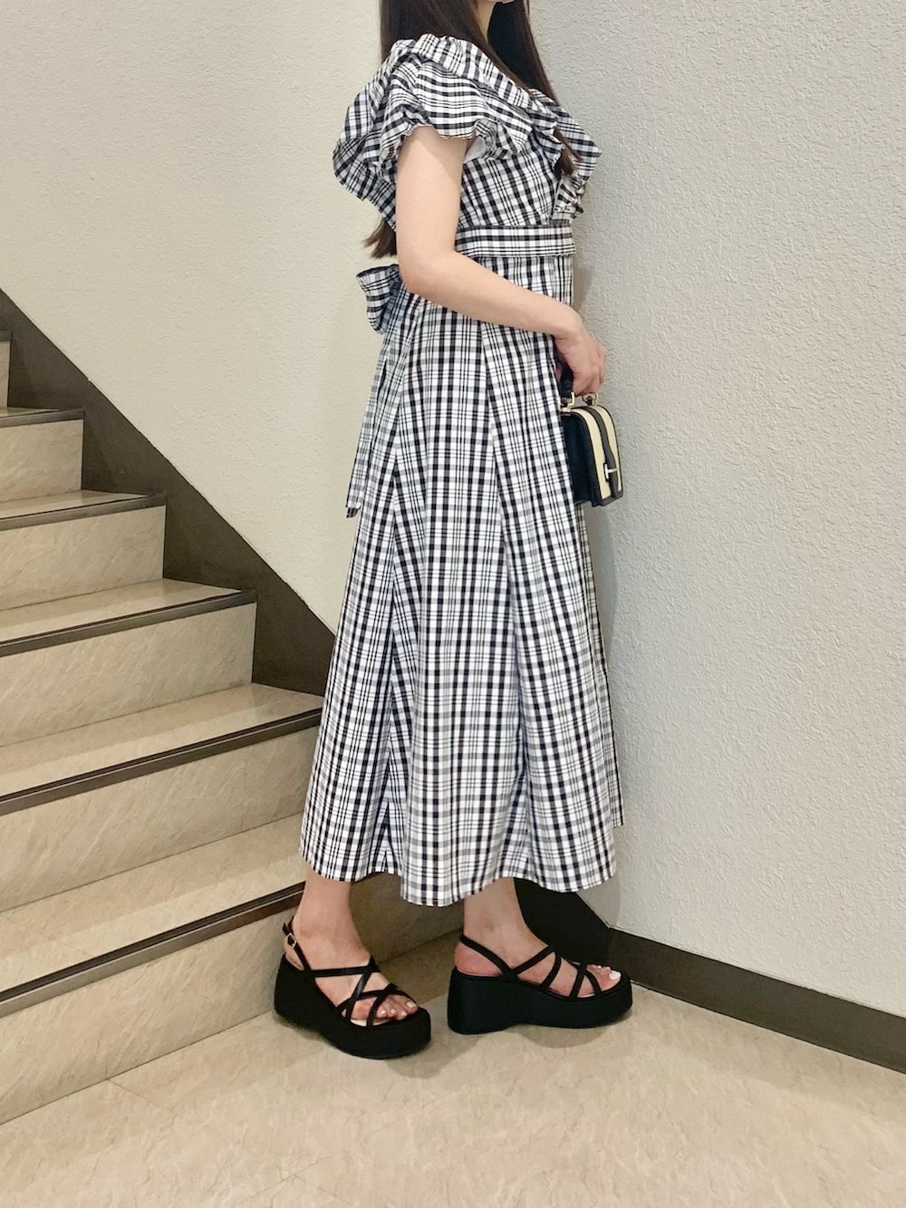 その他のワンピース、ブラック系のサンダル、ブラック系のハンドバッグを着用したレディースの夏コーディネートの2枚目の写真