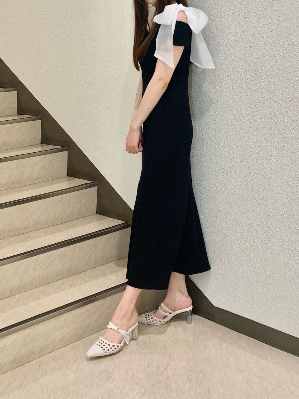 ホワイト系のパンプス、ブラック系のワンピースを着用したレディースの夏コーディネートの2枚目の写真