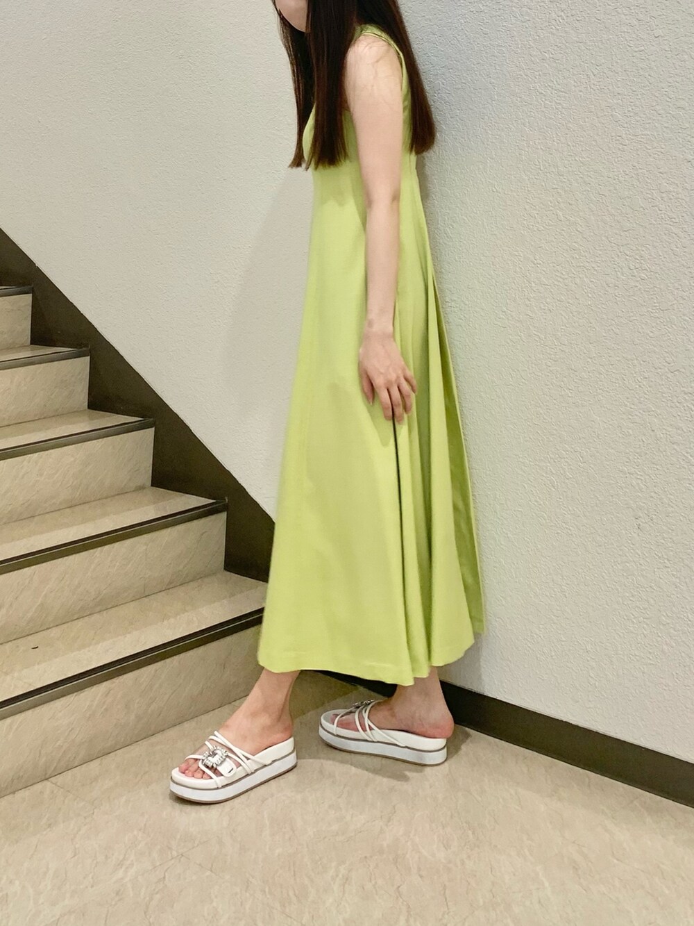 ホワイト系のカーディガン/ボレロ、グリーン系のワンピース、ホワイト系のサンダルを着用したレディースの春コーディネートの2枚目の写真