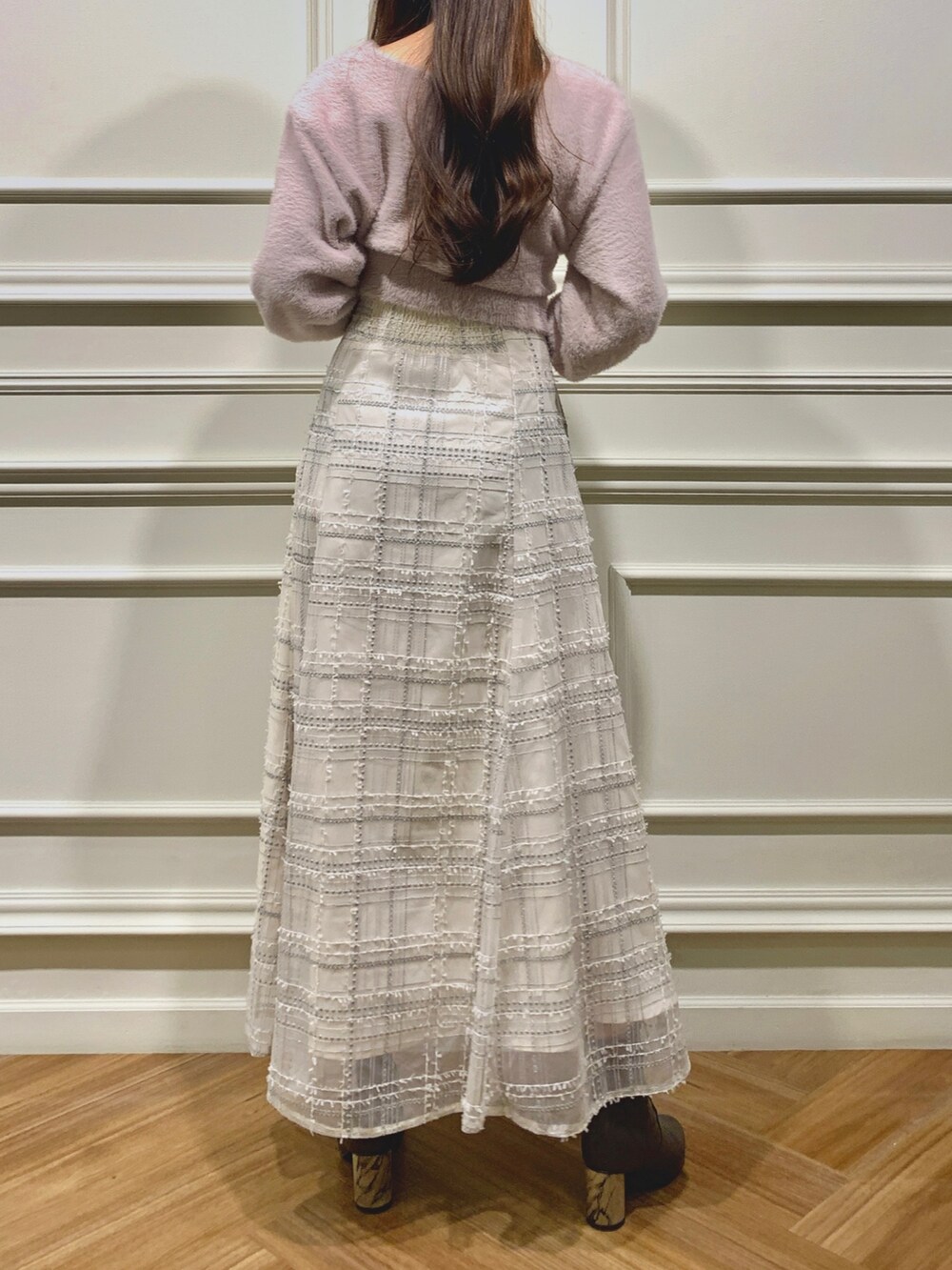 ホワイト系のスカート、ホワイト系のショルダーバッグ、ピンク系のニット/セーターを着用したレディースの秋コーディネートの3枚目の写真