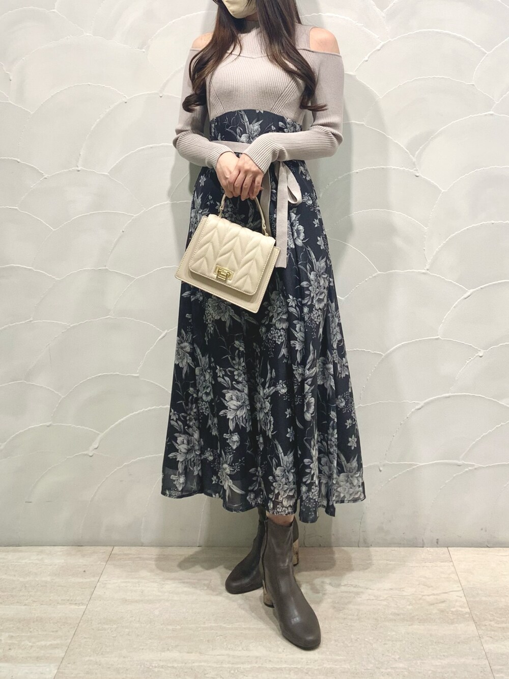 ベージュ系のワンピース、ベージュ系のショルダーバッグ、ブラウン系のブーツを着用したレディースの秋コーディネートの2枚目の写真