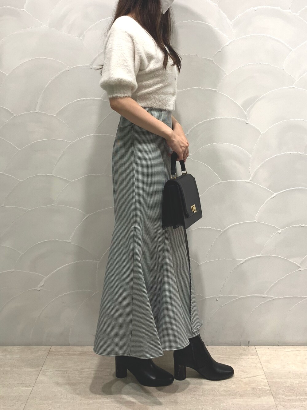 ブラック系のハンドバッグ、ホワイト系のカーディガン/ボレロ、その他のスカートを着用したレディースの夏コーディネートの2枚目の写真