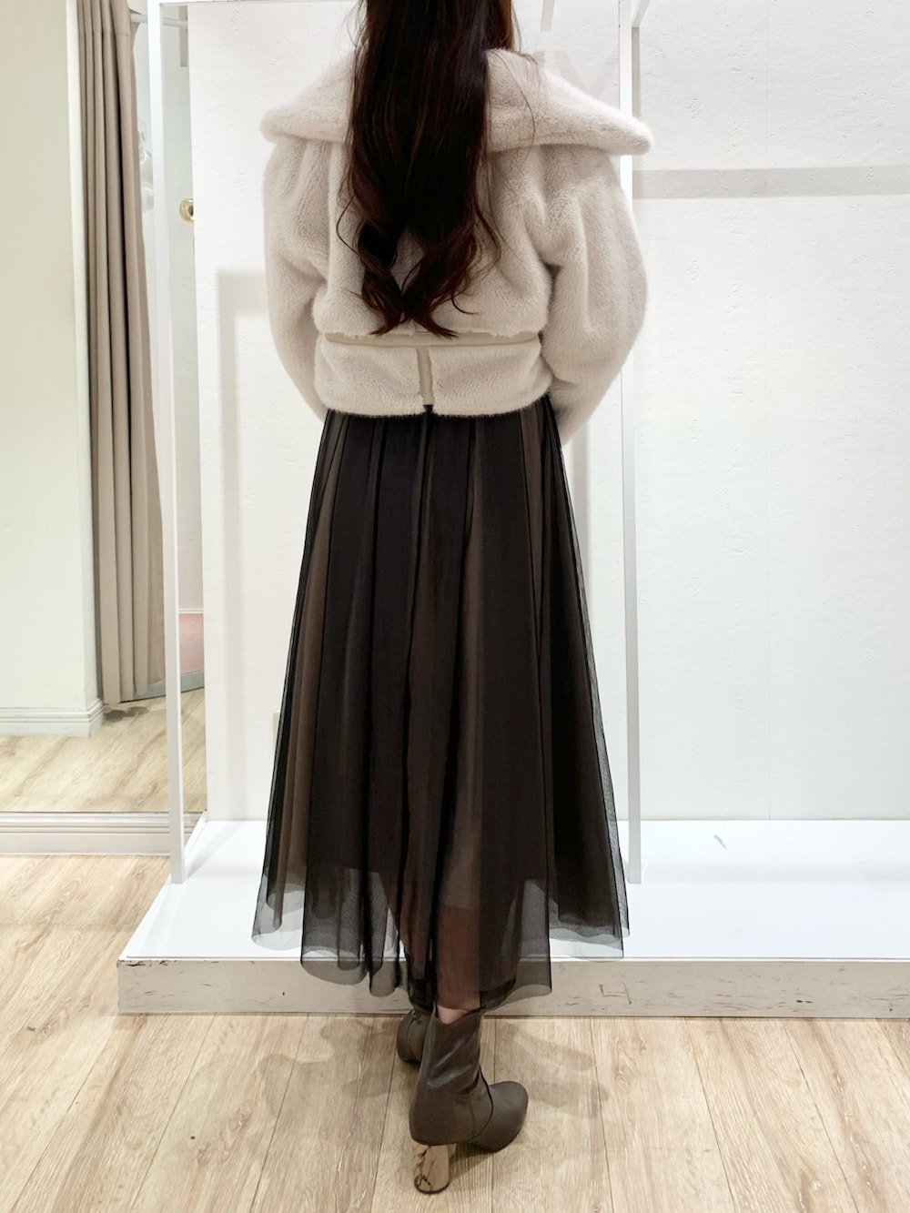 ブラック系のワンピース、ホワイト系のショルダーバッグ、ホワイト系のその他アウターを着用したレディースの秋コーディネートの3枚目の写真