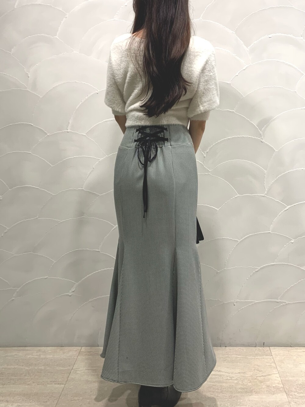 ブラック系のハンドバッグ、ホワイト系のカーディガン/ボレロ、その他のスカートを着用したレディースの夏コーディネートの3枚目の写真