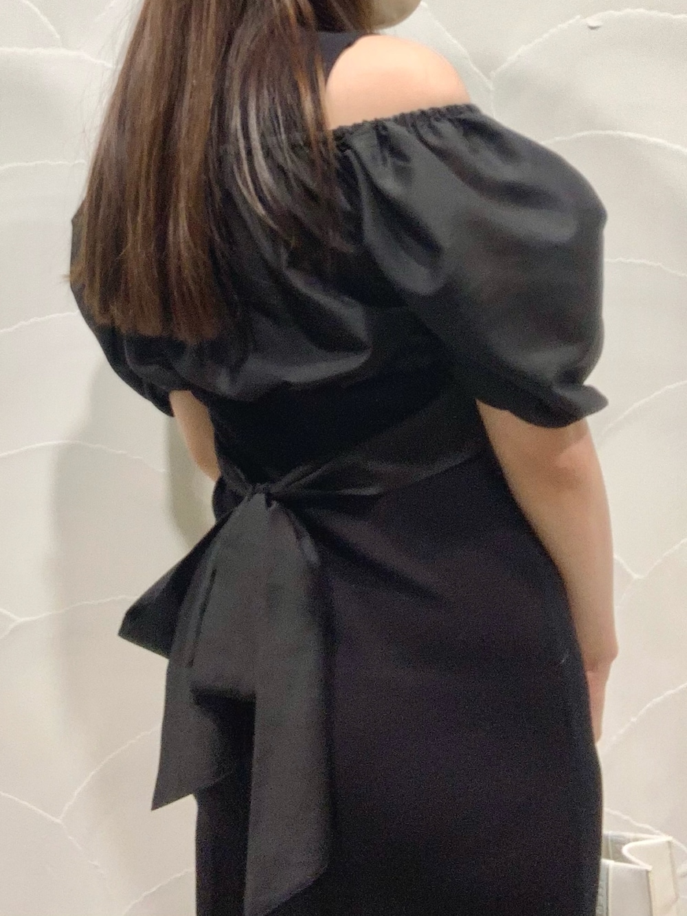 ホワイト系のトートバッグ、ブラック系のブーツ、ブラック系のワンピースを着用したレディースの春コーディネートの4枚目の写真