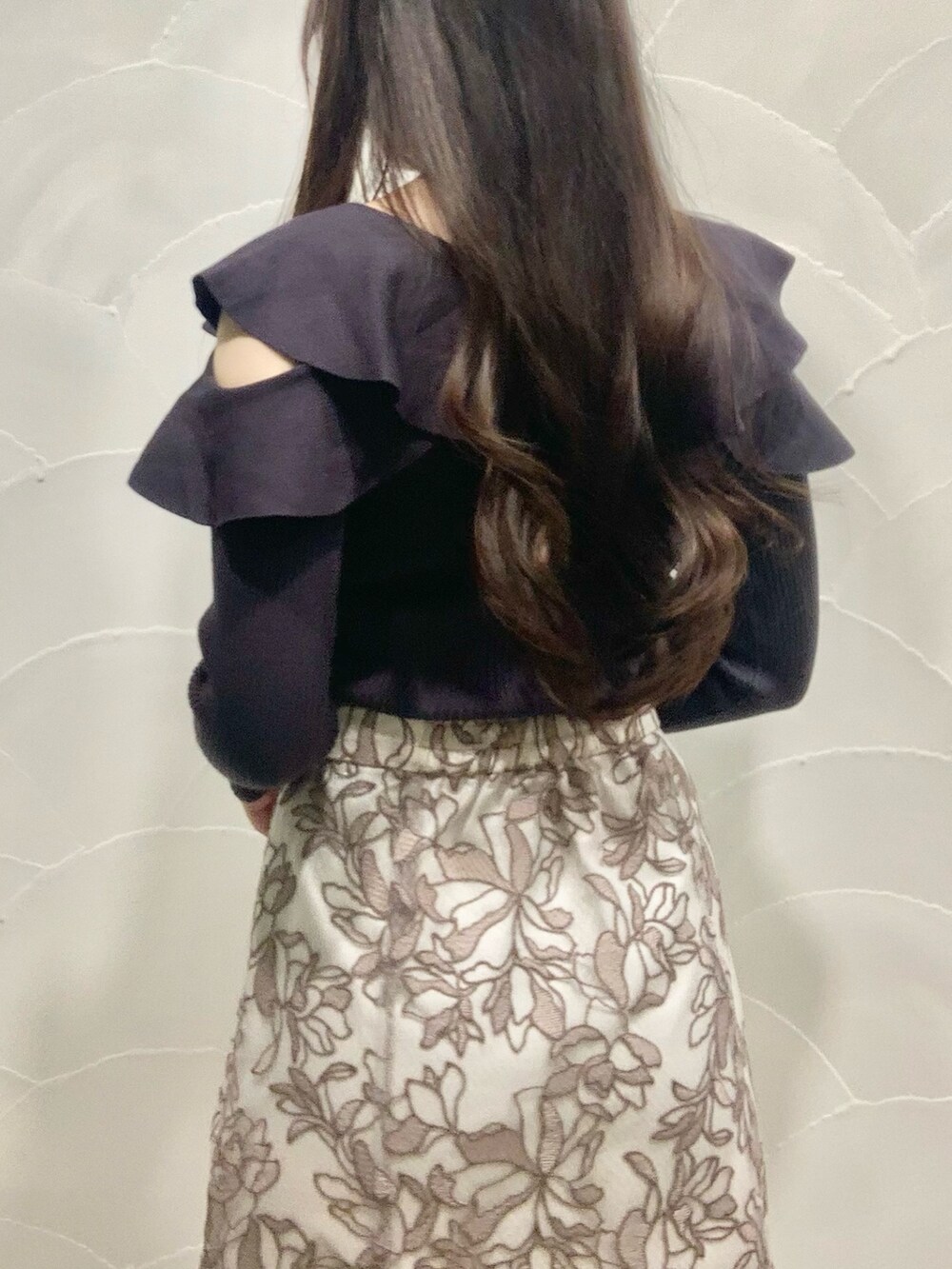 ピンク系のスカート、グレー系のニット/セーター、ホワイト系のダウンジャケット/コートを着用したレディースの秋コーディネートの6枚目の写真