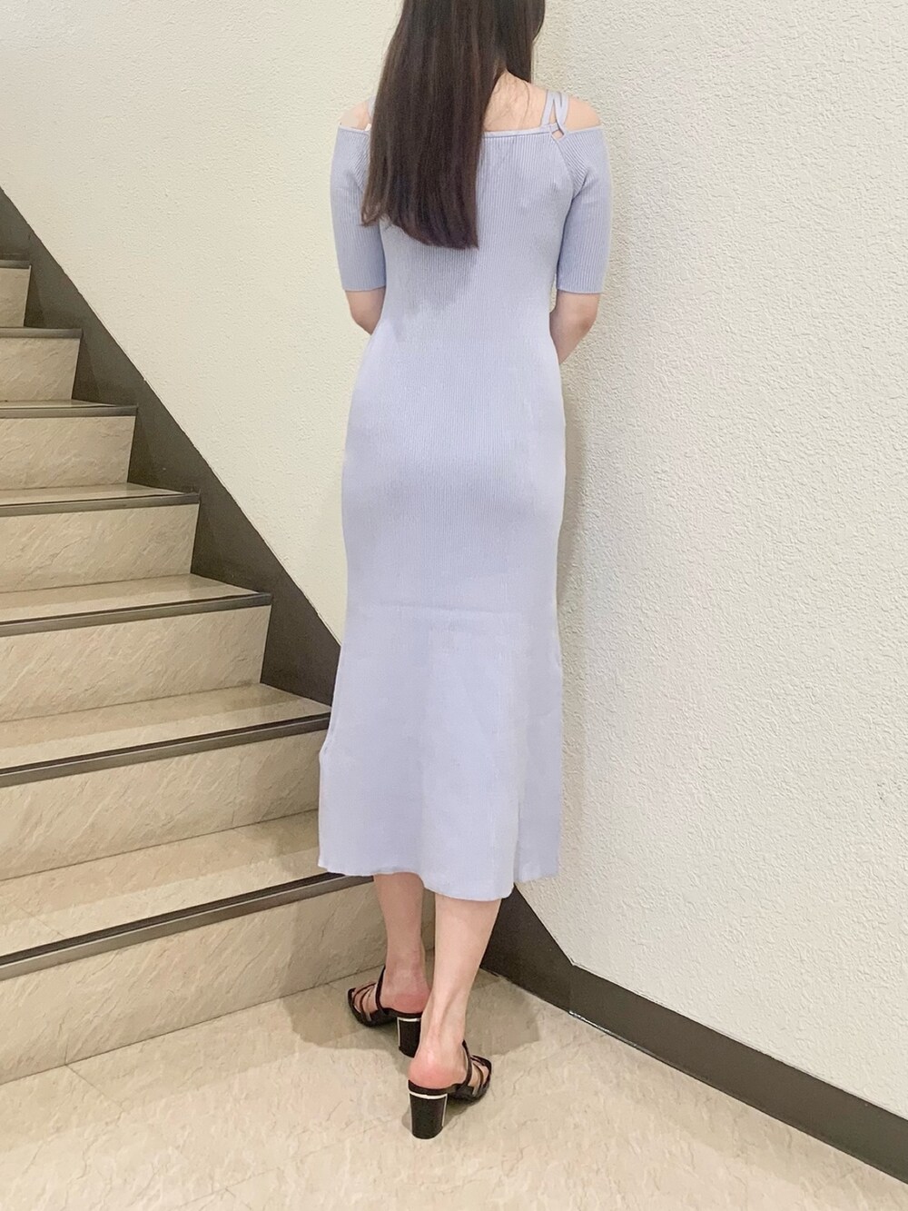 ブラック系のハンドバッグ、ブラック系のサンダル、ブルー系のワンピースを着用したレディースの春コーディネートの3枚目の写真