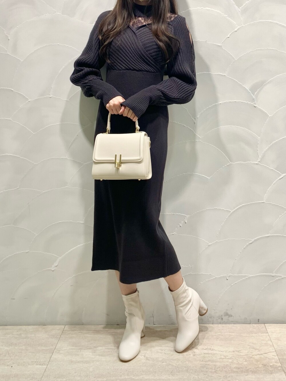 グレー系のワンピース、ホワイト系のショルダーバッグ、ホワイト系のブーツを着用したレディースの秋コーディネートの3枚目の写真
