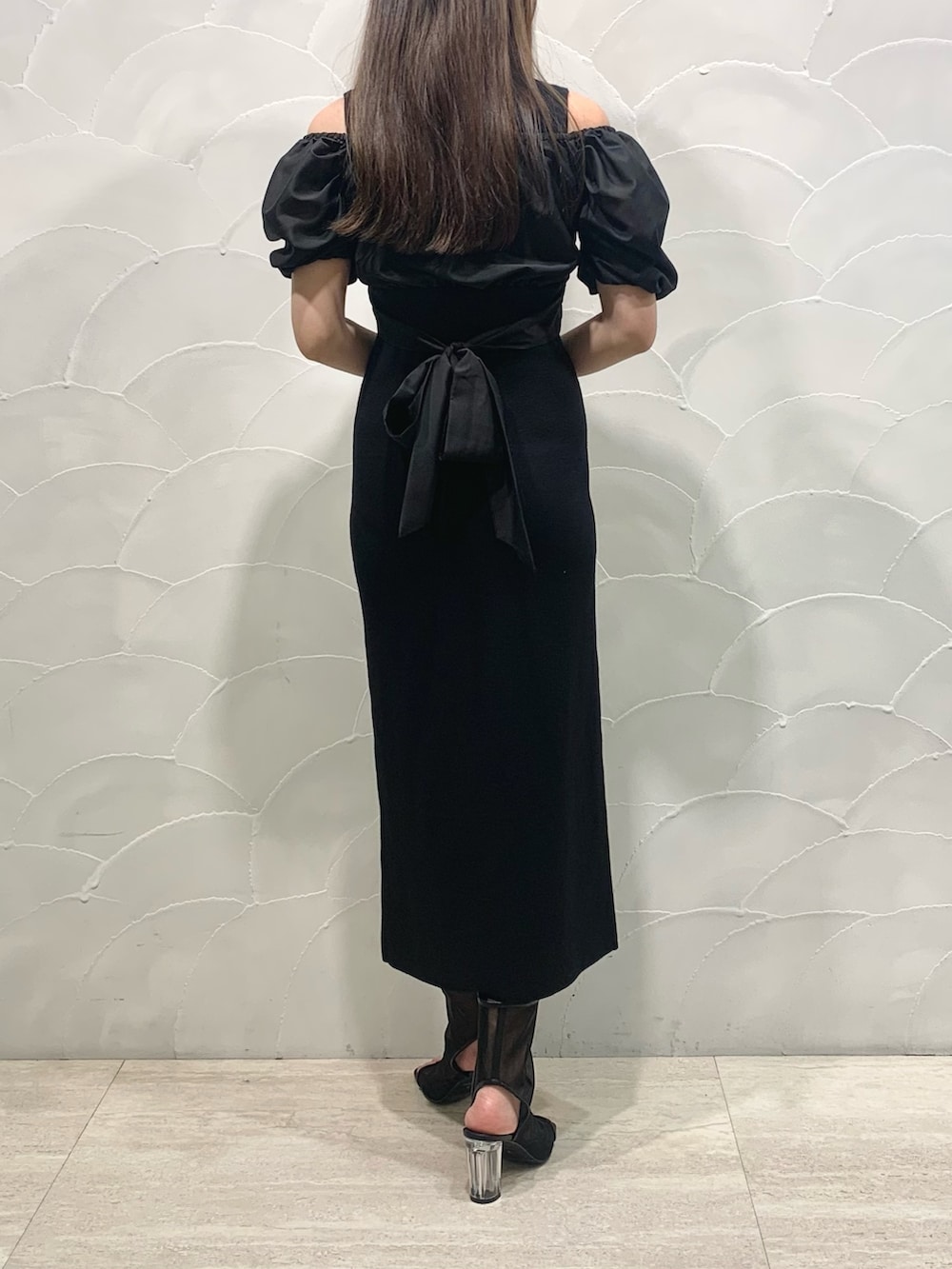 ホワイト系のトートバッグ、ブラック系のブーツ、ブラック系のワンピースを着用したレディースの春コーディネートの3枚目の写真