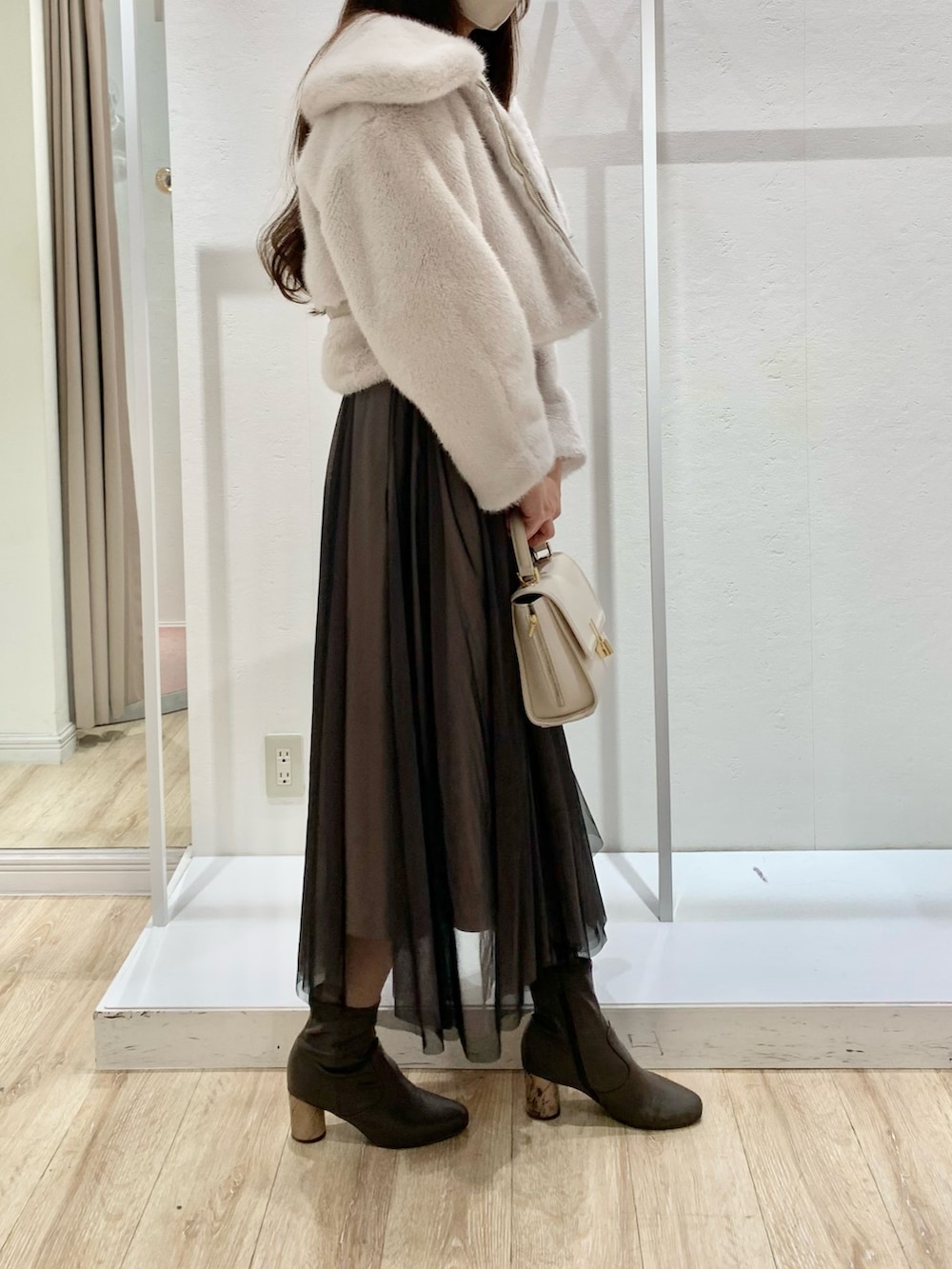 ブラック系のワンピース、ホワイト系のショルダーバッグ、ホワイト系のその他アウターを着用したレディースの秋コーディネートの2枚目の写真