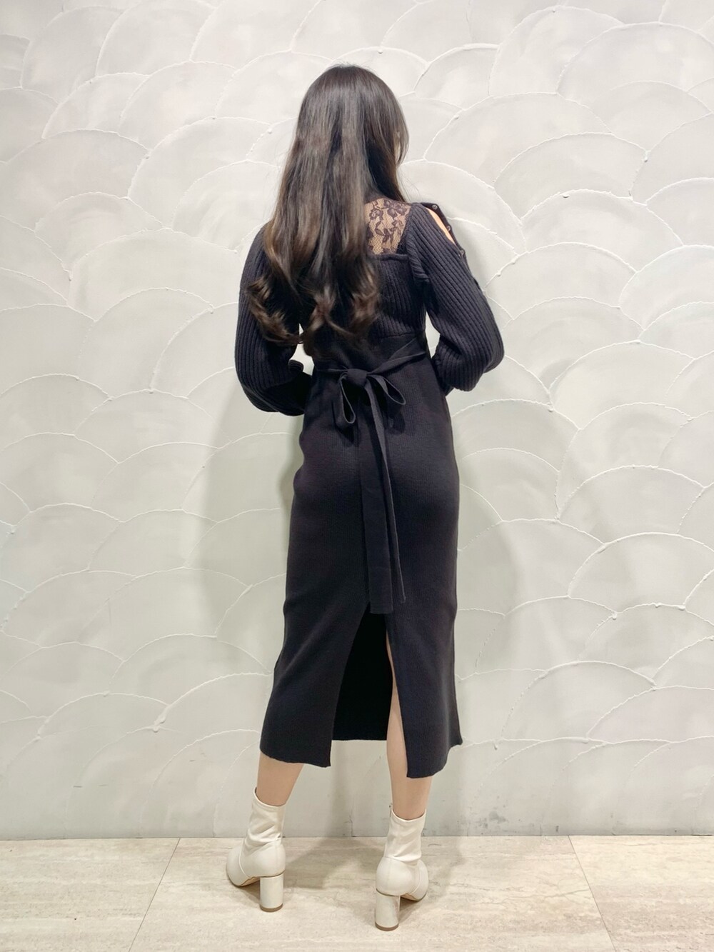 グレー系のワンピース、ホワイト系のショルダーバッグ、ホワイト系のブーツを着用したレディースの秋コーディネートの2枚目の写真