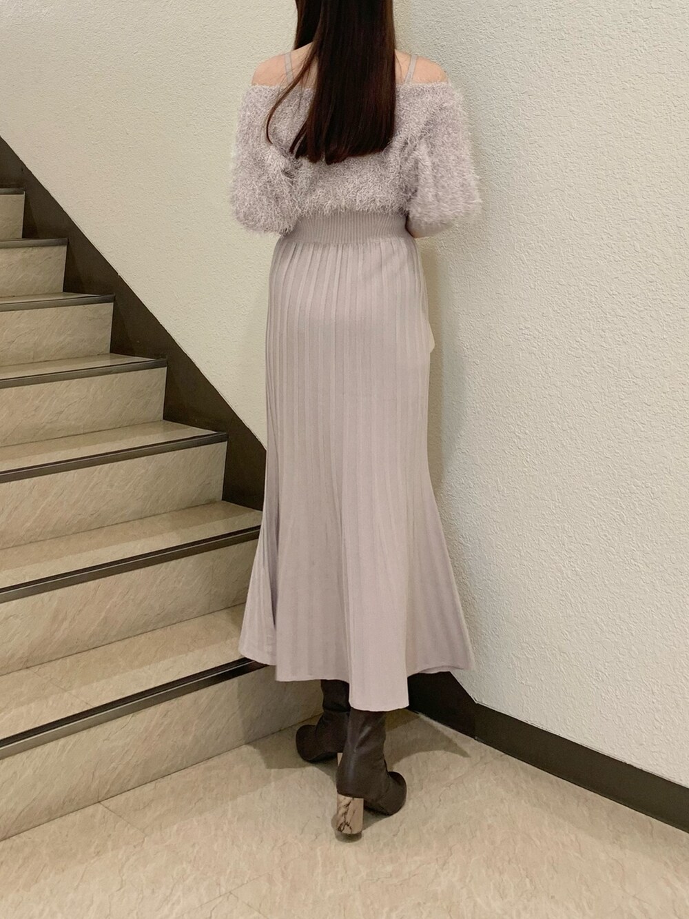 ベージュ系のワンピース、ホワイト系のハンドバッグ、ブラウン系のブーツを着用したレディースの冬コーディネートの3枚目の写真