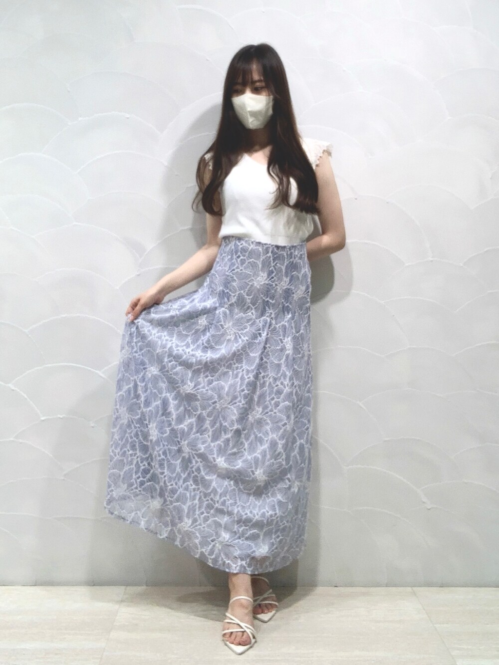 ホワイト系のニット/セーター、ホワイト系のサンダル、ブルー系のスカートを着用したレディースの夏コーディネートの3枚目の写真