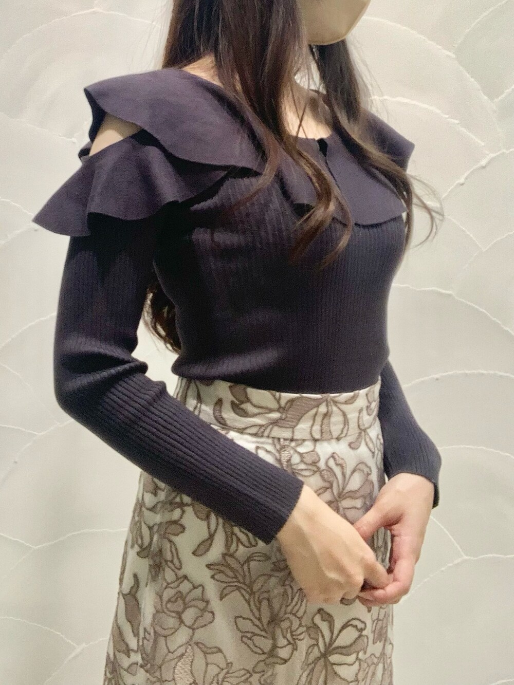 ピンク系のスカート、グレー系のニット/セーター、ホワイト系のダウンジャケット/コートを着用したレディースの秋コーディネートの5枚目の写真