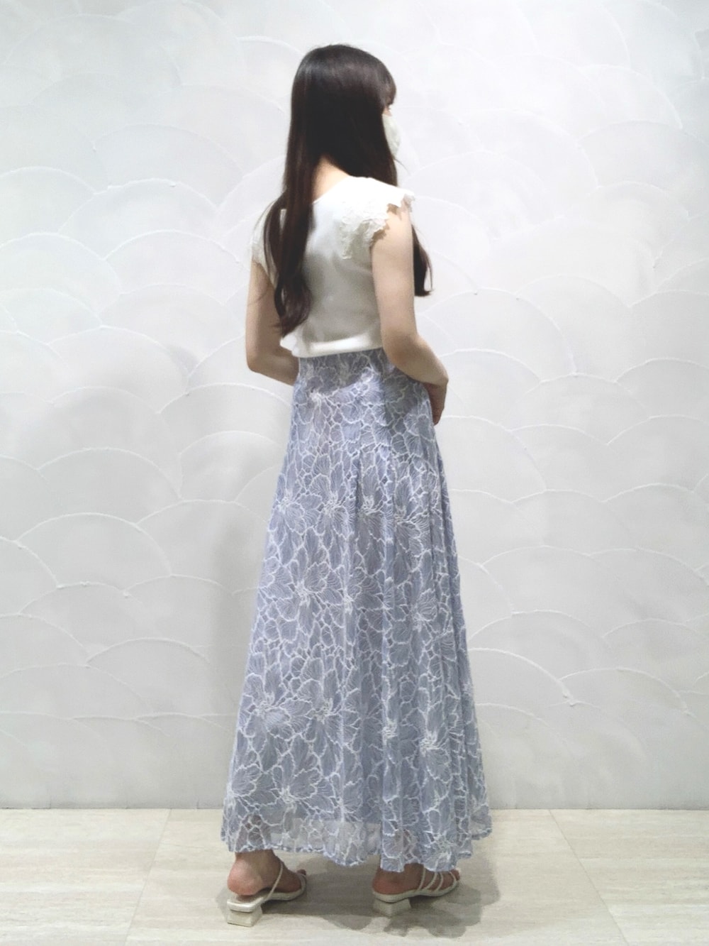 ホワイト系のニット/セーター、ホワイト系のサンダル、ブルー系のスカートを着用したレディースの夏コーディネートの2枚目の写真