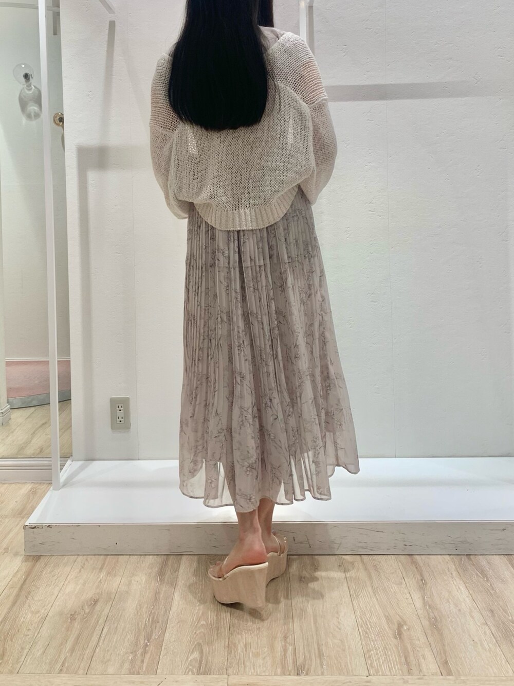 ベージュ系のショルダーバッグ、ピンク系のワンピース、ホワイト系のカーディガン/ボレロを着用したレディースの春コーディネートの3枚目の写真