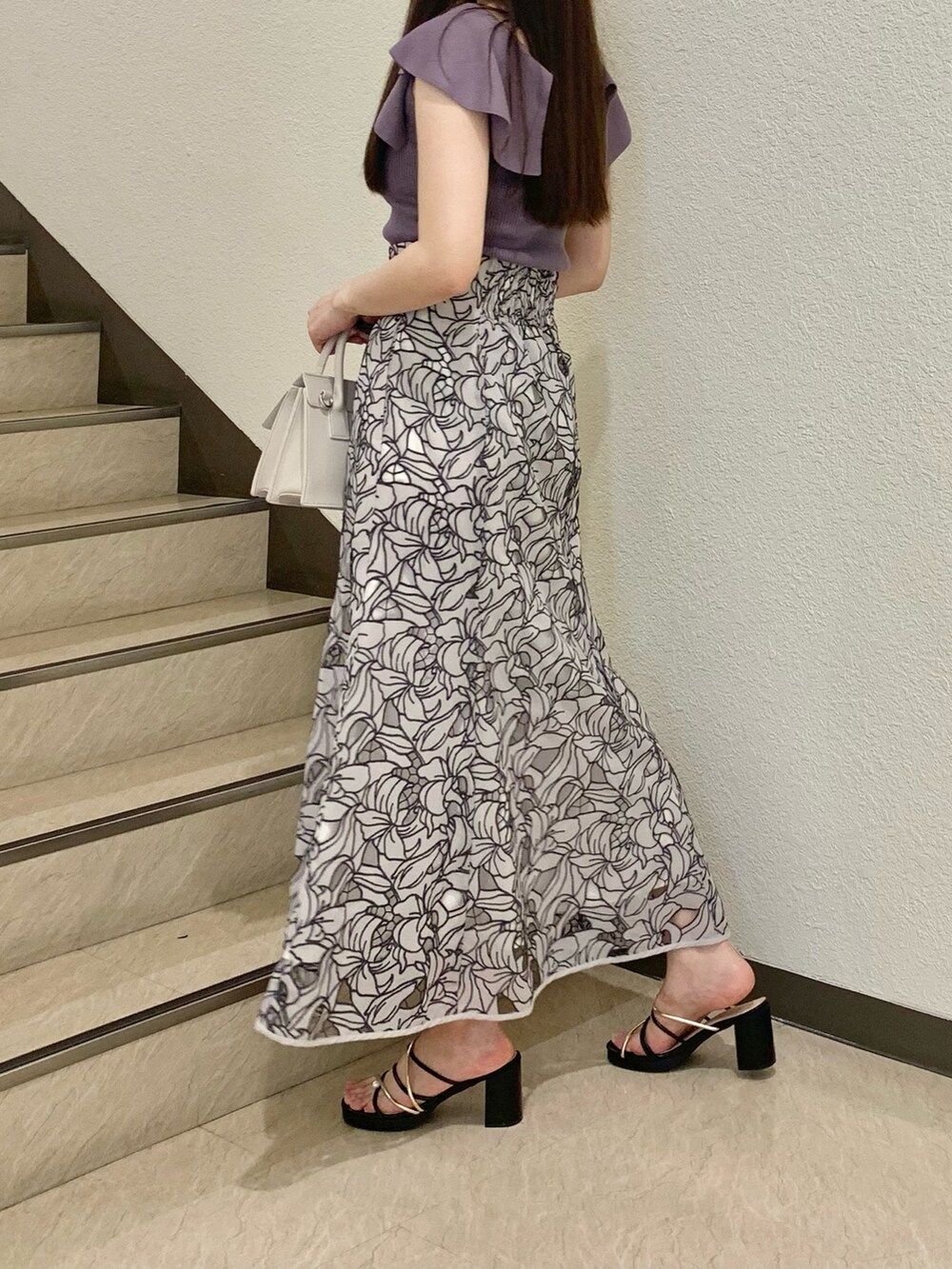 パープル系のニット/セーター、ベージュ系のショルダーバッグ、ベージュ系のスカートを着用したレディースの春コーディネートの3枚目の写真