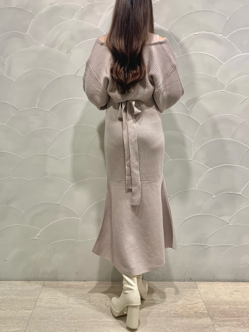 ピンク系のワンピース、ホワイト系のショルダーバッグ、ホワイト系のブーツを着用したレディースの秋コーディネートの3枚目の写真