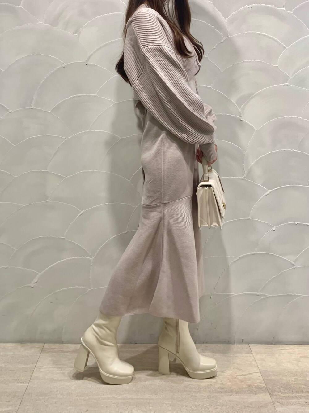 ピンク系のワンピース、ホワイト系のショルダーバッグ、ホワイト系のブーツを着用したレディースの秋コーディネートの2枚目の写真