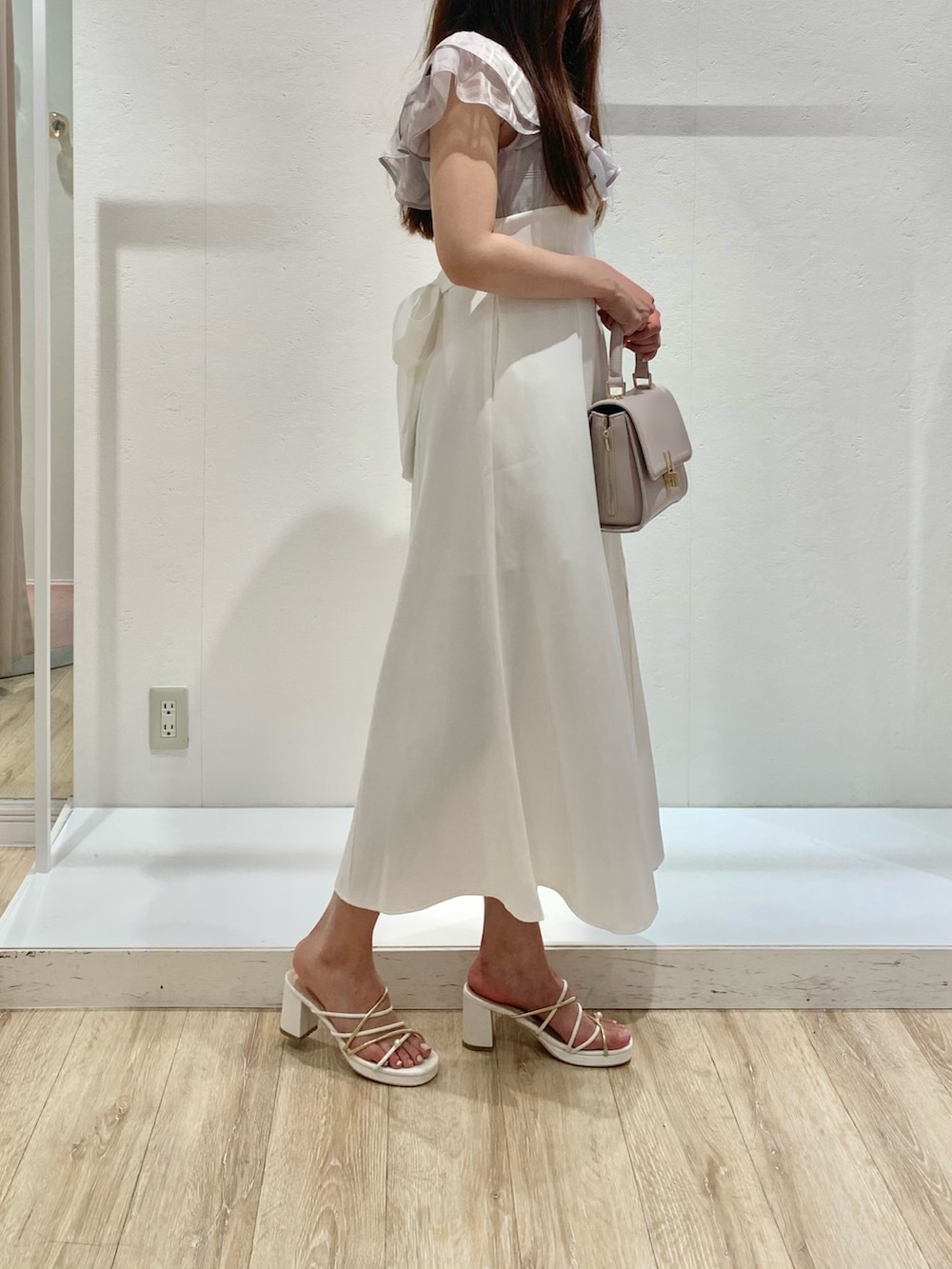 パープル系のワンピース、ピンク系のショルダーバッグ、ホワイト系のサンダルを着用したレディースの夏コーディネートの2枚目の写真