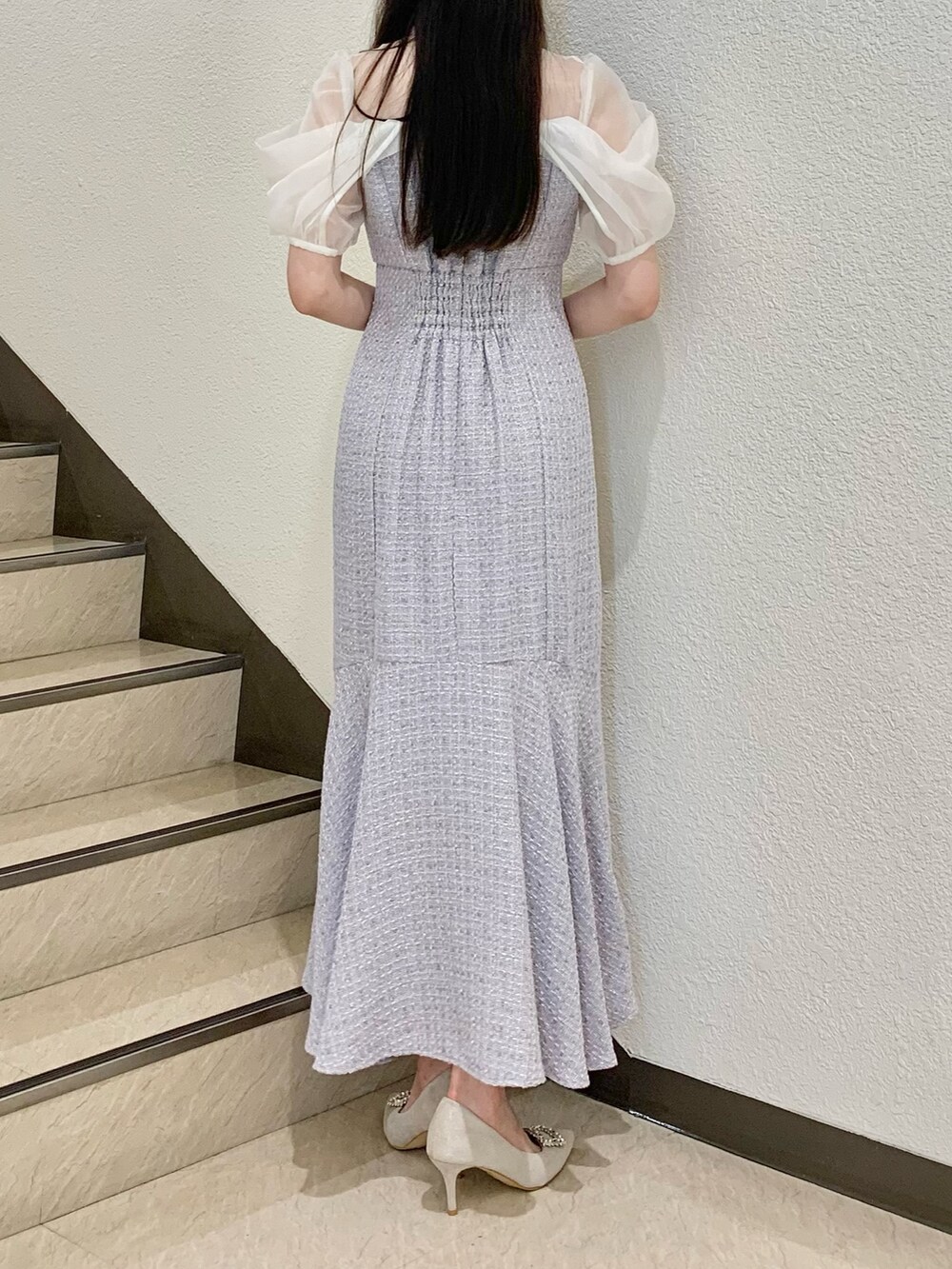 ホワイト系のハンドバッグ、パープル系のワンピース、ホワイト系のパンプスを着用したレディースの夏コーディネートの2枚目の写真