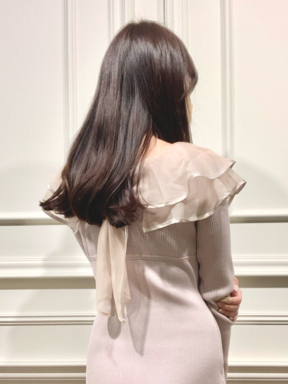 ブラック系のハンドバッグ、ブラウン系のブーツ、ピンク系のワンピースを着用したレディースの冬コーディネートの5枚目の写真