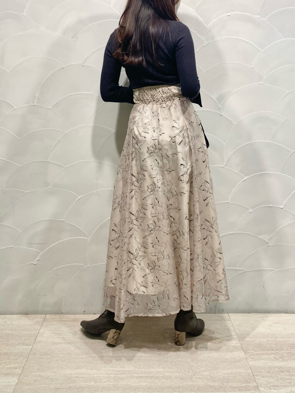 ベージュ系のスカート、グレー系のニット/セーター、ベージュ系のライダースジャケットを着用したレディースの冬コーディネートの4枚目の写真