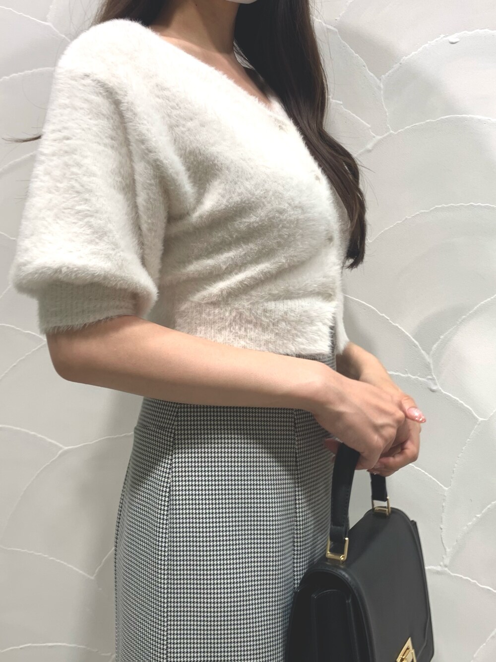 ブラック系のハンドバッグ、ホワイト系のカーディガン/ボレロ、その他のスカートを着用したレディースの夏コーディネートの4枚目の写真