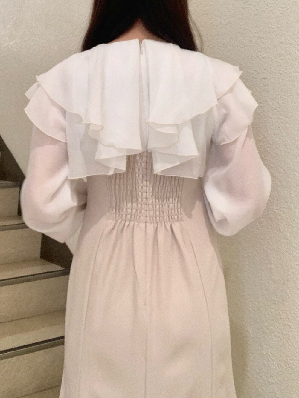 ブラウン系のブーツ、ベージュ系のワンピース、ホワイト系のハンドバッグを着用したレディースの冬コーディネートの5枚目の写真