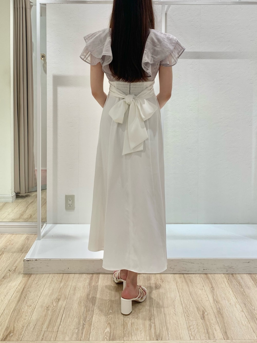 パープル系のワンピース、ピンク系のショルダーバッグ、ホワイト系のサンダルを着用したレディースの夏コーディネートの3枚目の写真