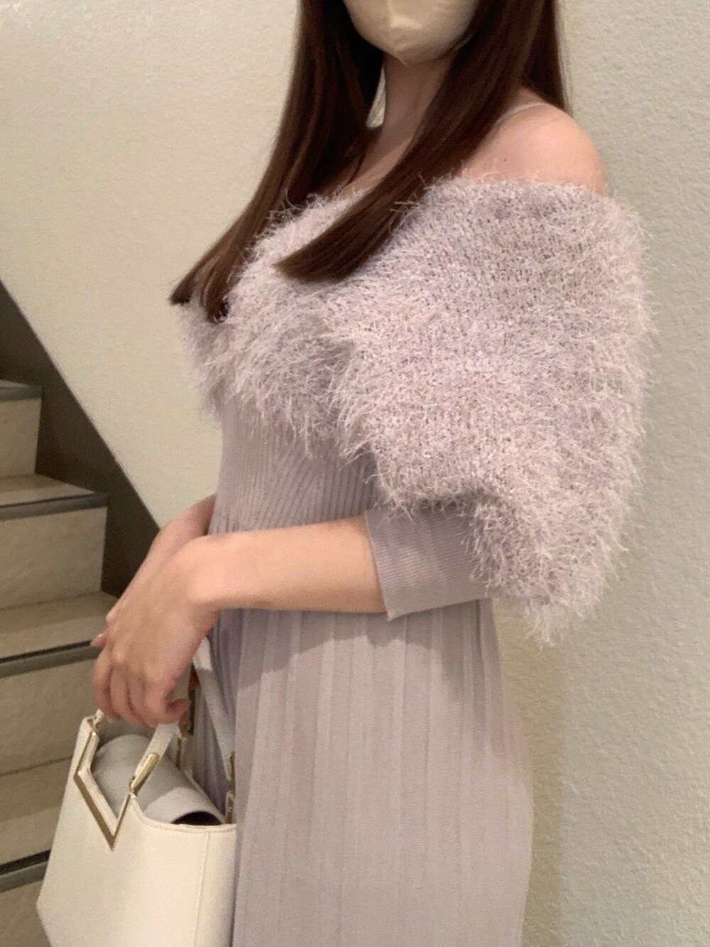 ベージュ系のワンピース、ホワイト系のハンドバッグ、ブラウン系のブーツを着用したレディースの冬コーディネートの4枚目の写真