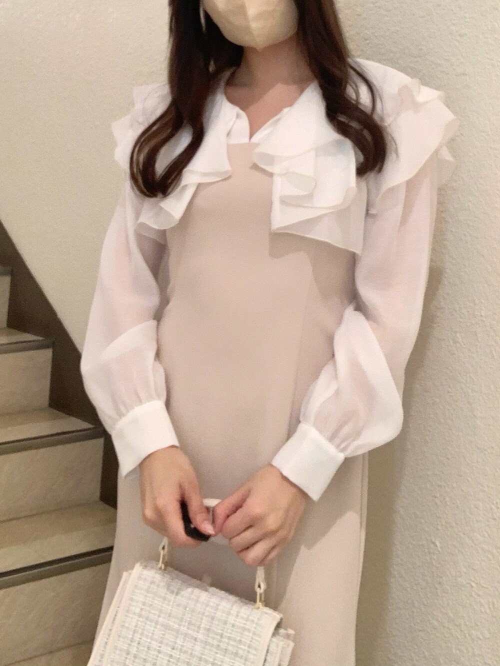 ブラウン系のブーツ、ベージュ系のワンピース、ホワイト系のハンドバッグを着用したレディースの冬コーディネートの4枚目の写真