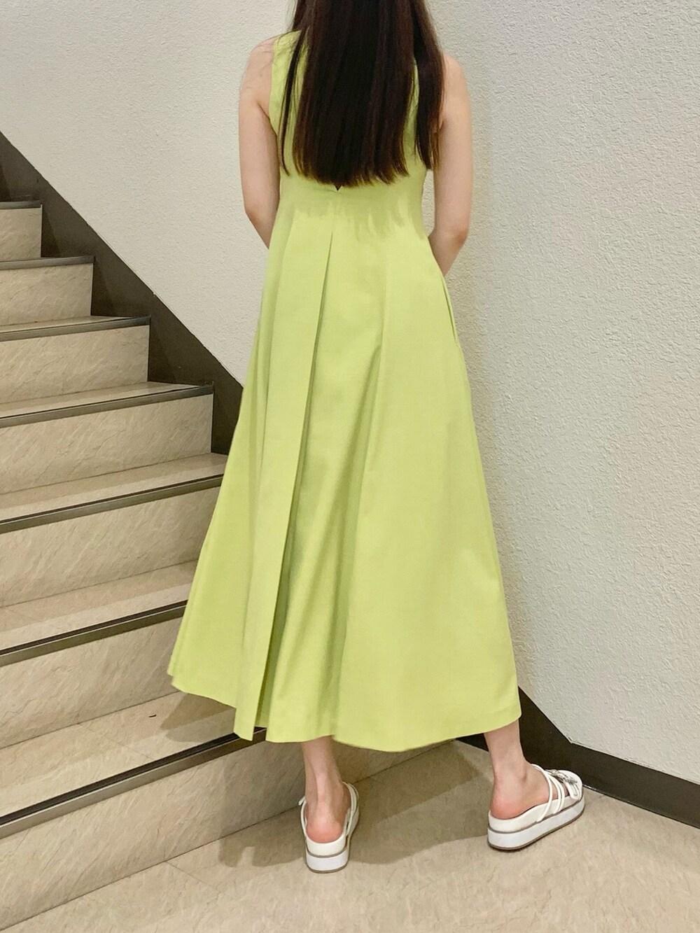 ホワイト系のカーディガン/ボレロ、グリーン系のワンピース、ホワイト系のサンダルを着用したレディースの春コーディネートの3枚目の写真